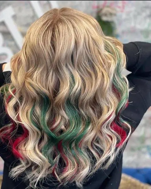 Wavy blonde hair with green dyed streaks
