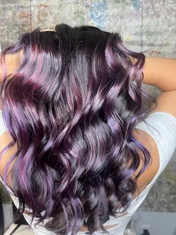 Very shiny black hair with purple dyed streaks